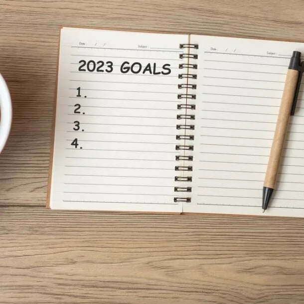 2023 GOAL with notebook, black coffee cup and pen on wood table,